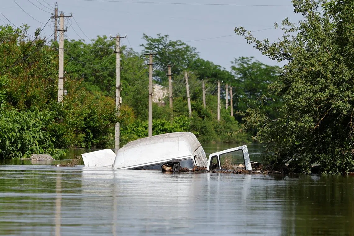 A view shows an abandoned vehicle in a flooded residential area that submerged in water following the collapse of the Nova Kakhovka dam in the course of the Russia-Ukraine conflict, in the settlement of Korsunka, in the Kherson region of Ukraine, on June 7, 2023.