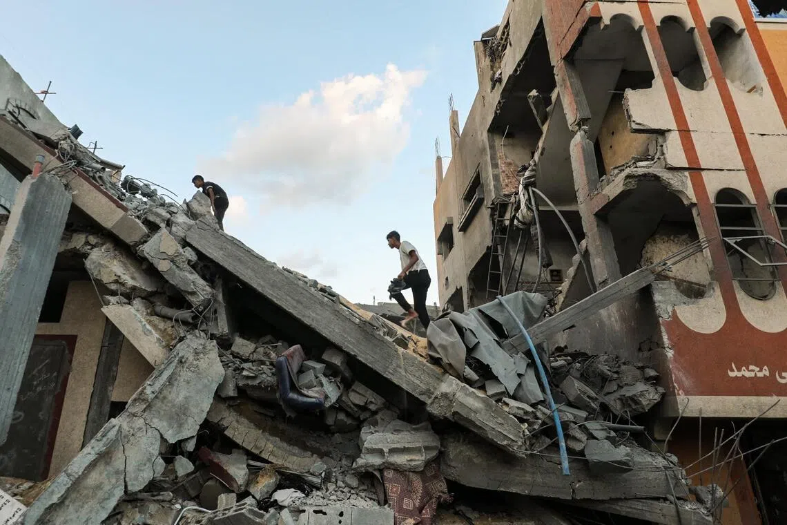 Palestinians check the rubble of a building hit by an Israeli strike in the Nuseirat refugee camp in the central Gaza Strip, on Sept 25.
