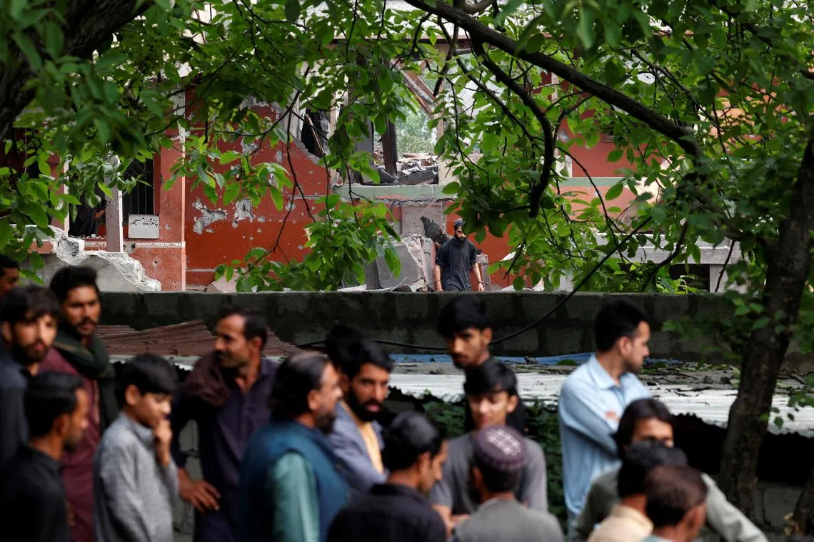 People gather next to a damaged portion of Bilal Mosque after it was hit by an Indian strike in Muzaffarabad, the capital of Pakistan-administered Kashmir, May 7, 2025. REUTERS/Akhtar Soomro