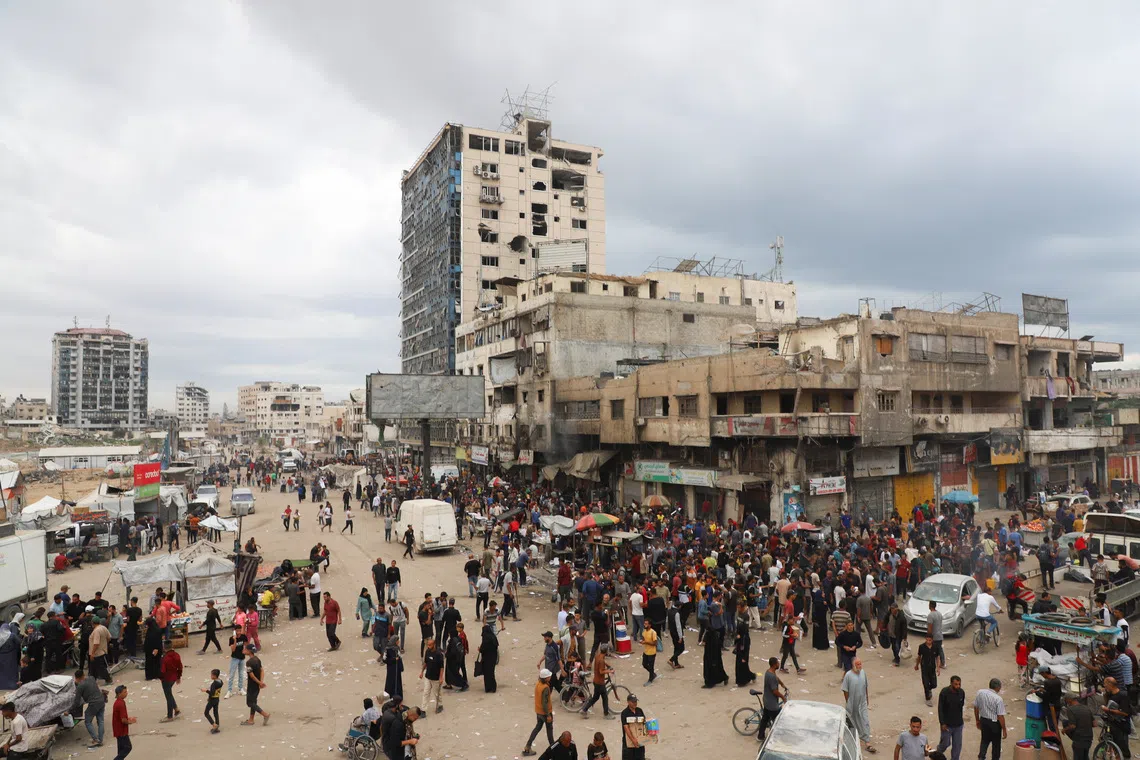 Palestinians gather at a street market during a ceasefire between Israel and Hamas, in Gaza City, October 12, 2025. REUTERS/Ebrahim Hajjaj
