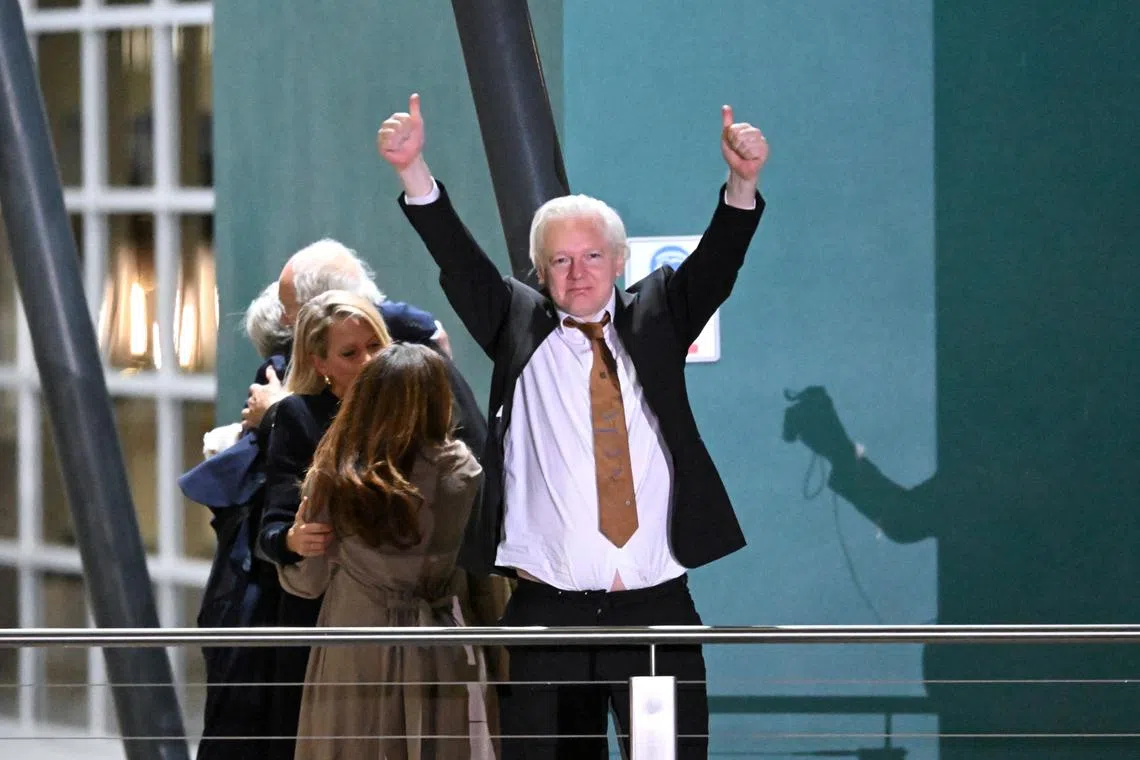 WikiLeaks founder Julian Assange gestures at supporters after arriving at Canberra Airport, Canberra, Australia June 26, 2024. AAP Image/Lukas Coch via REUTERS