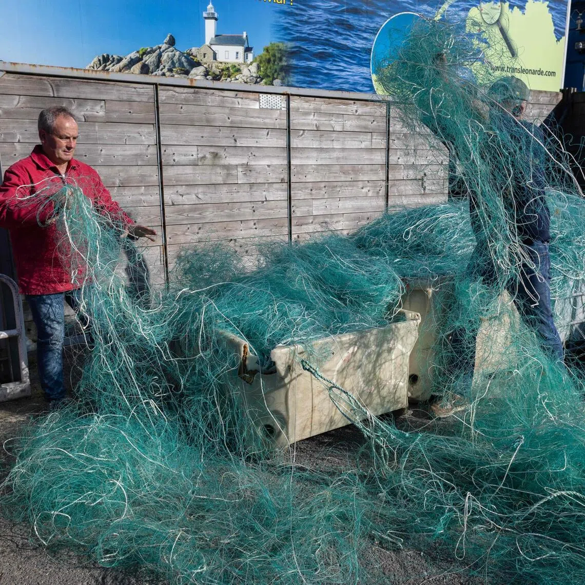 French charity association Kernic Solidarites member in charge of logistic Christian Abaziou (right) and its president Gerard Le Duff (left) sort out fishing nets to be sent to Ukraine.