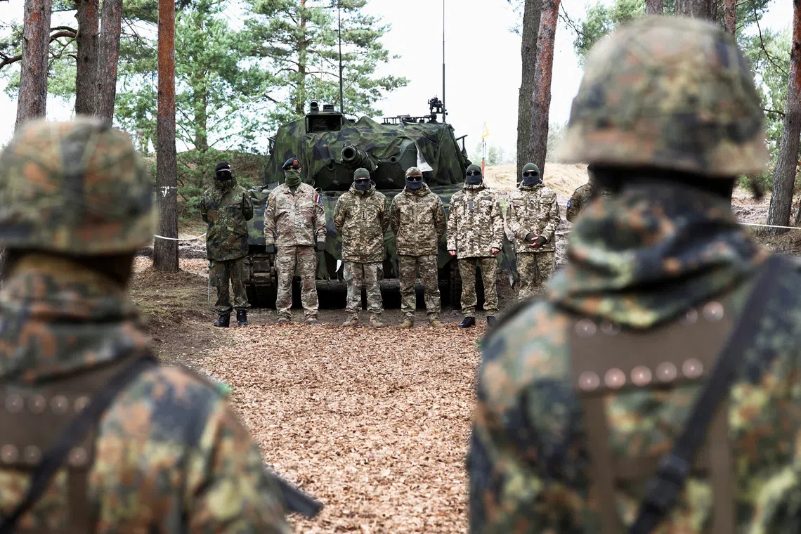 Soldiers stand in line at a training site as they undergo maintenance training on Leopard 1 A5 tanks, at the German army Bundeswehr base, part of the EU Military Assistance Mission in support of Ukraine (EUMAM UA) in Klietz, Germany, February 23, 2024. REUTERS/Liesa Johannssen