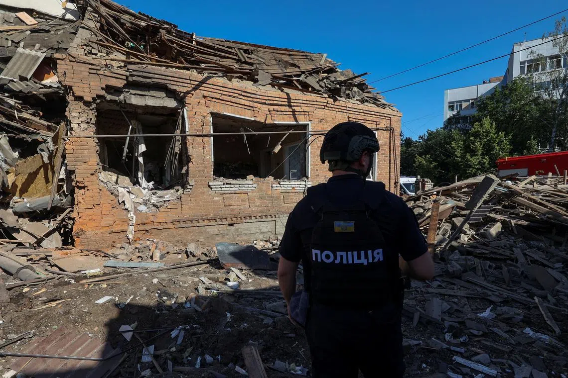 A police officer inspects the site where a residential building was heavily damaged by a Russian air strike, amid Russia's attack on Ukraine, in Kharkiv, Ukraine July 3, 2024. REUTERS/Vyacheslav Madiyevskyy