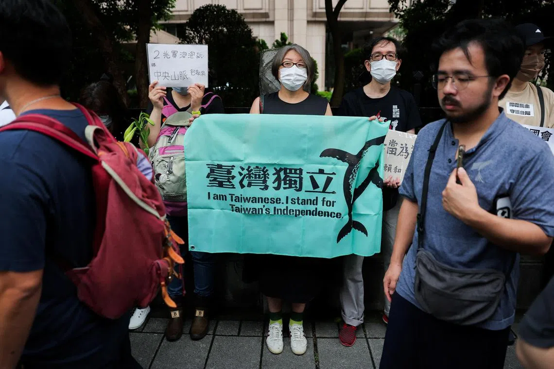 A woman holds a sign showing support for Taiwan's independence as people gather outside during a session at the Parliament in Taipei, Taiwan May 24, 2024. REUTERS/Ann Wang
