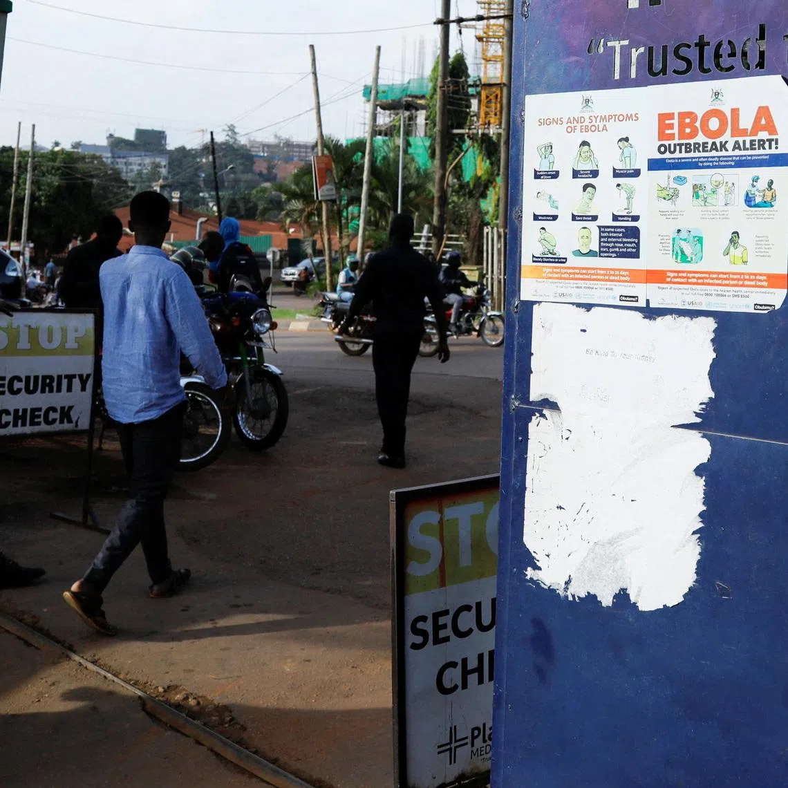 People walk past an advocacy poster against the spread of Ebola virus, as aid agencies intensify efforts to contain a new Ebola outbreak involving the Bundibugyo Virus at the Platinum Medical Centre in Kampala, Uganda May 26, 2026. REUTERS/Abubaker Lubowa