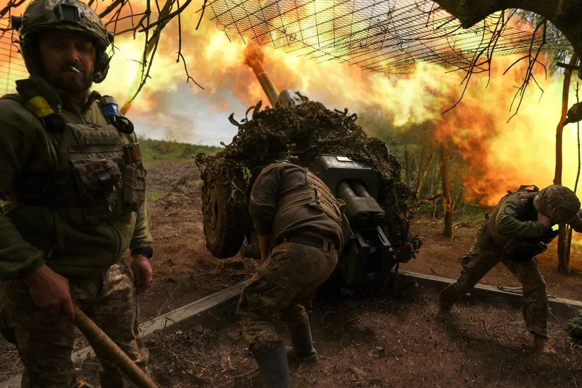 Ukrainian servicemen fire a howitzer towards Russian troops, near the town of Soledar, in Ukraine's Donetsk region.