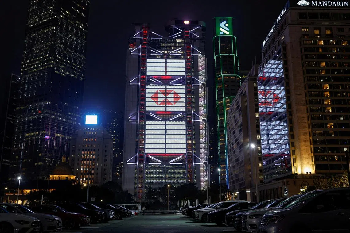 FILE PHOTO: The headquarters of HSBC and Standard Chartered Bank stand in the central business district at dusk, in Hong Kong, China March 15, 2024. REUTERS/Tyrone Siu/File Photo