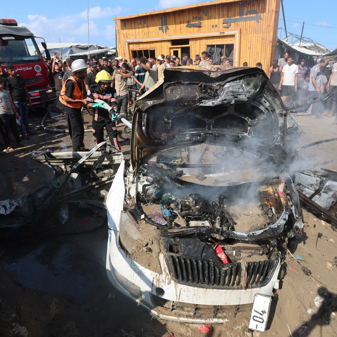 Palestinian firefighters extinguishing a fire on a vehicle hit by an Israeli air strike in Khan Younis, in the southern Gaza Strip, on Sept 23.