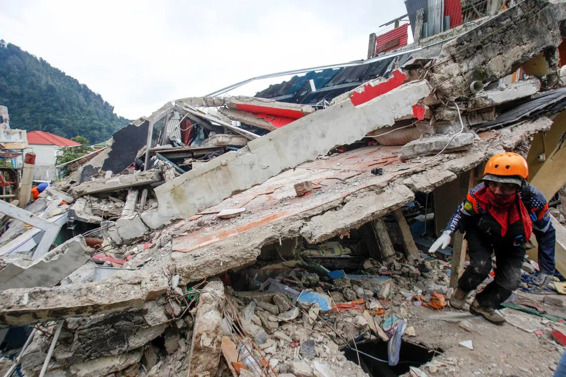 A rescuer walks among the rubble of collapsed buildings in Cianjur, Indonesia, on Nov 22, 2022.