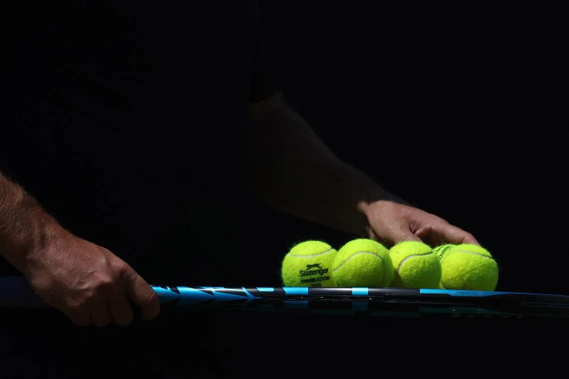 Tennis - Queen's Club Championships - Queen's Club, London, Britain - June 16, 2025 A member of the coaching team of Britain's Jack Draper holds a racket with Wimbledon logo tennis balls ahead of his round of 32 match against Jenson Brooksby of the U.S. REUTERS/Toby Melville/File Photo