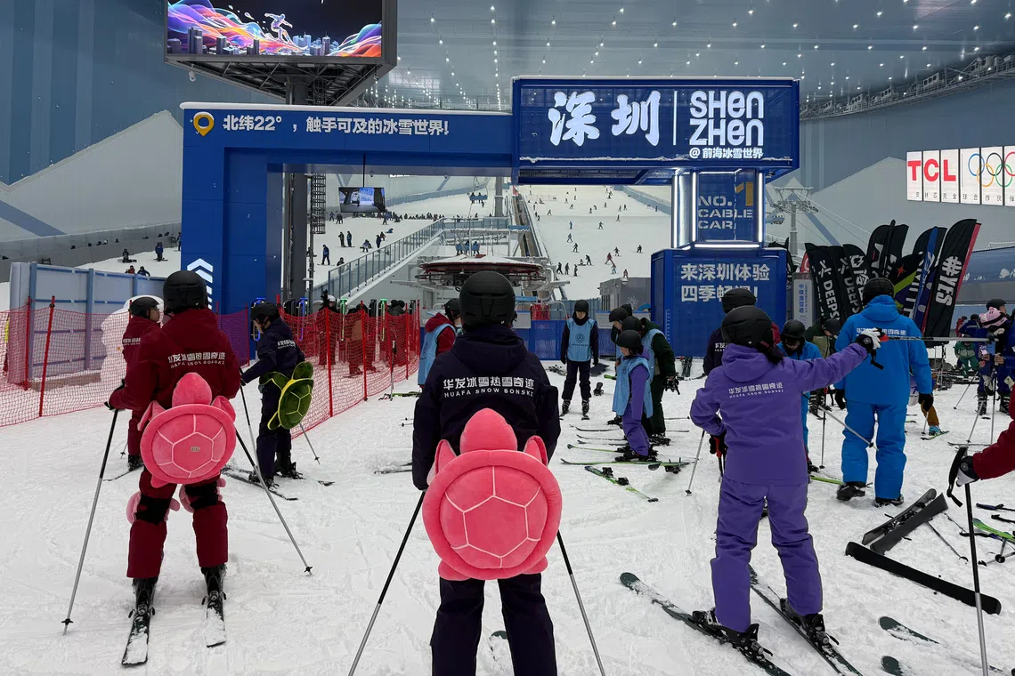 Wobbly first-timers donning turtle-shaped butt pads stood in line for beginner slopes at the Huafa Ice and Snow World  in Shenzhen on Oct 1.
