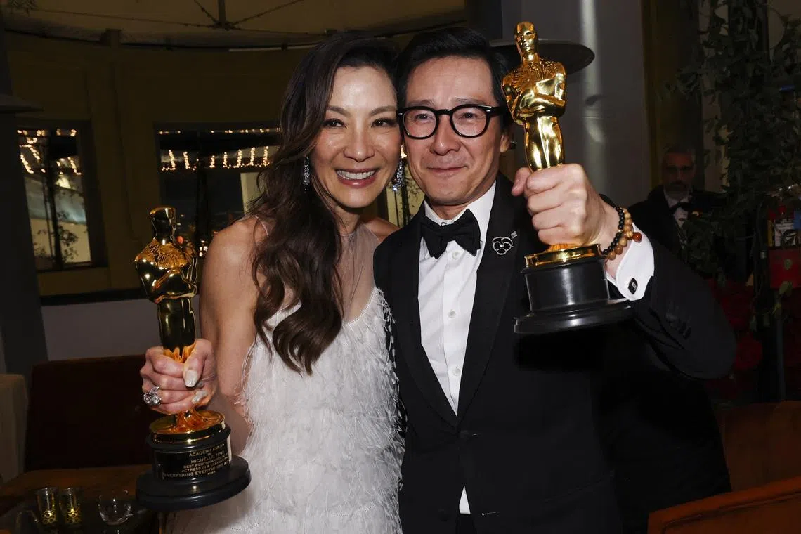 Actress Michelle Yeoh (right) and actor Ke Huy Quan pose with their awards following the Oscars show on March 12, 2023.