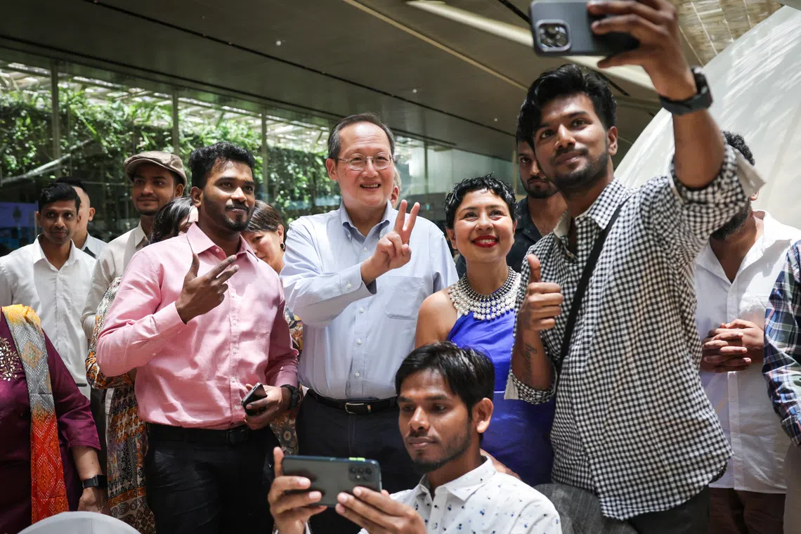 Manpower Minister Tan See Leng taking a picture with migrant workers during ItsRainingRaincoats' 10th anniversary held at National Gallery Singapore on Sept 21.