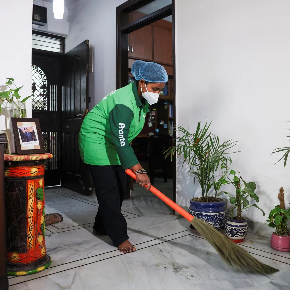 Laxmi, an employee with Pronto cleans a house with a broom in New Delhi, India, March 23, 2026. REUTERS/Bhawika Chhabra