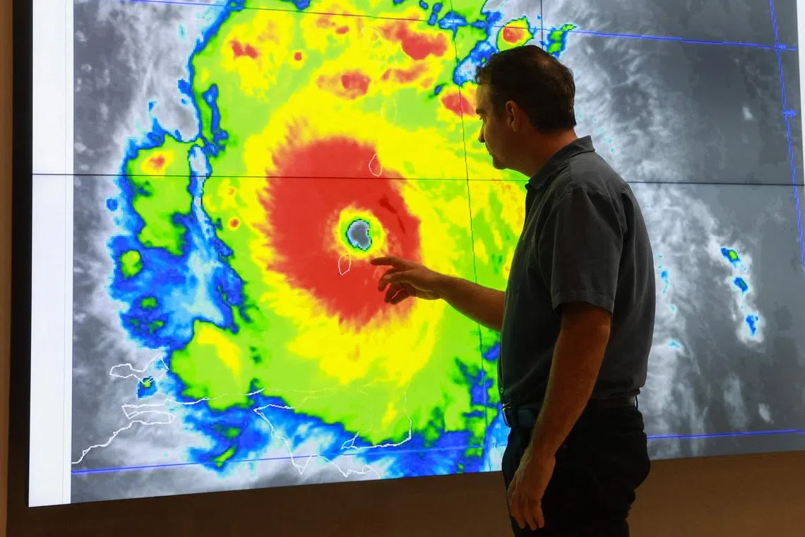 MIAMI, FLORIDA - JULY 01: John Cangialosi, Senior Hurricane Specialist at the National Hurricane Center, inspects a satellite image of Hurricane Beryl, the first hurricane of the 2024 season, at the National Hurricane Center on July 01, 2024 in Miami, Florida. On Monday afternoon, the storm, centered 30 miles west-northwest of Carriacou Island, became the strongest hurricane this early in the season in this area of the Atlantic.   Joe Raedle/Getty Images/AFP (Photo by JOE RAEDLE / GETTY IMAGES NORTH AMERICA / Getty Images via AFP)