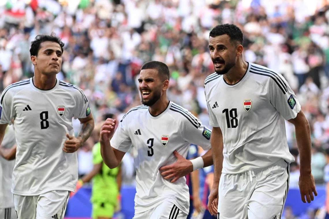 Iraq's forward Aymen Hussein celebrates with teammates after scoring his team's second goal.
