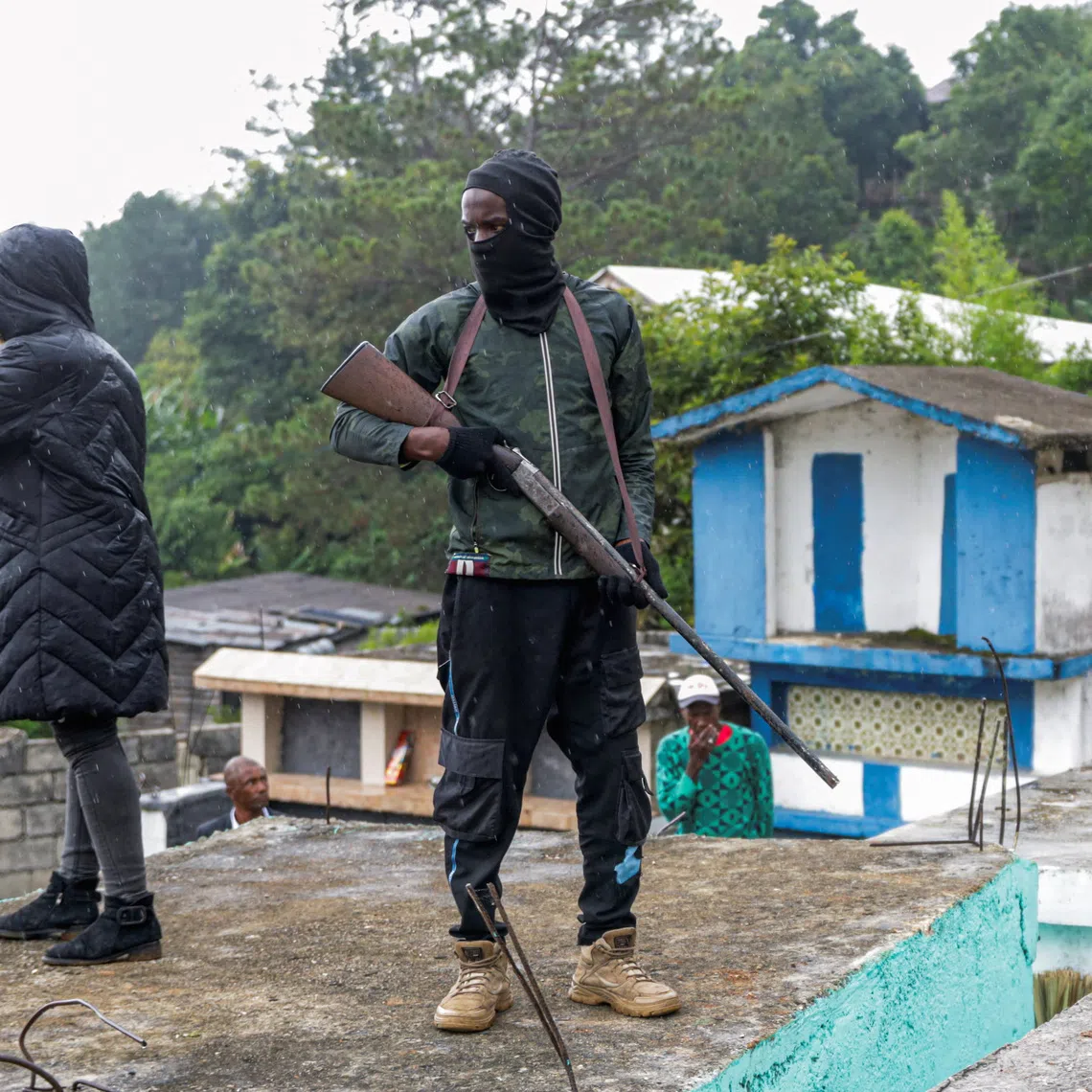 Men of the local defense force stand guard in a cemetery during a funeral service for people killed in an armed gang attack on August 23, in Kenscoff, Haiti, September 2, 2026. REUTERS/Patrice Noel