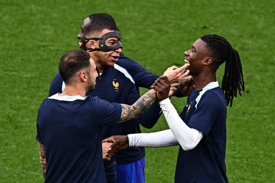A masked Mbappe taking part in a warm-up session with teammates before the start of France's June 21 match against the Netherlands.