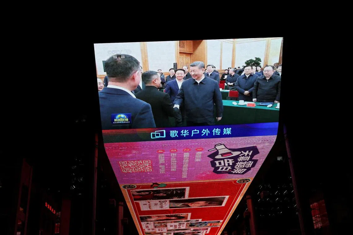 A giant screen at a shopping complex in Beijing shows news footage of Chinese President Xi Jinping shaking hands with Alibaba founder Jack Ma during a symposium on private enterprises on Feb 17. 