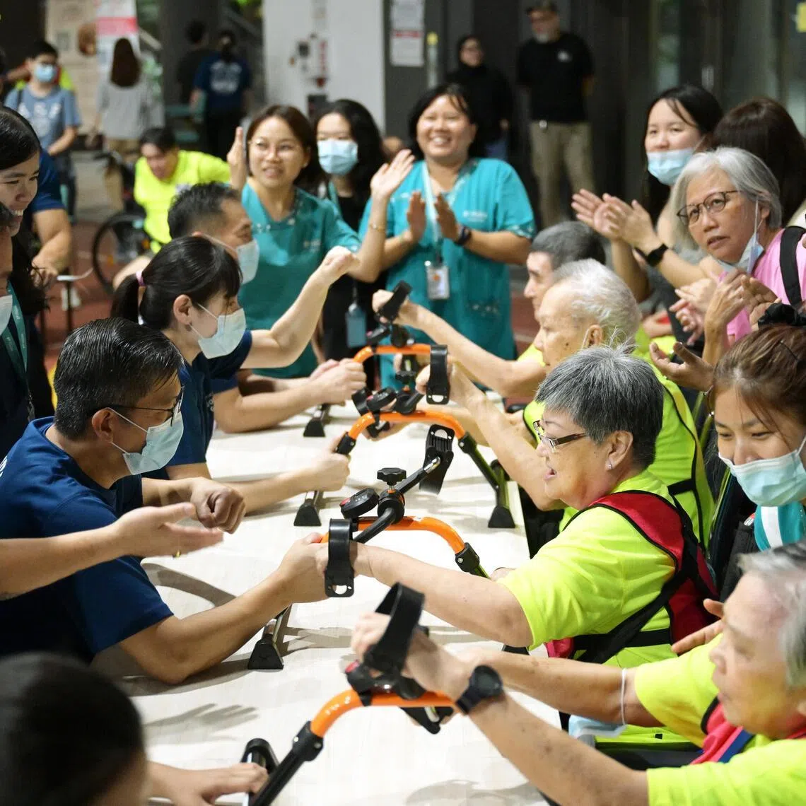 Staff cheer on their residents as they compete in the hand cycling event at the NTUC Health Golden Games in Jurong West on May 18.