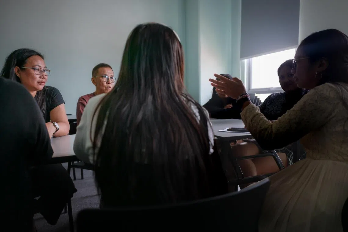 Pastor Billy Lee and cell group leader Monette speak with foreign domestic workers struggling with debt during a support session on Oct 11.