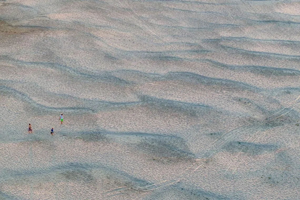 A drone view shows people on newly exposed sandbanks on the Danube River as water levels drop during prolonged hot weather and dry conditions, in Apatin, Serbia, July 26, 2026. REUTERS/Djordje Kojadinovic     TPX IMAGES OF THE DAY     