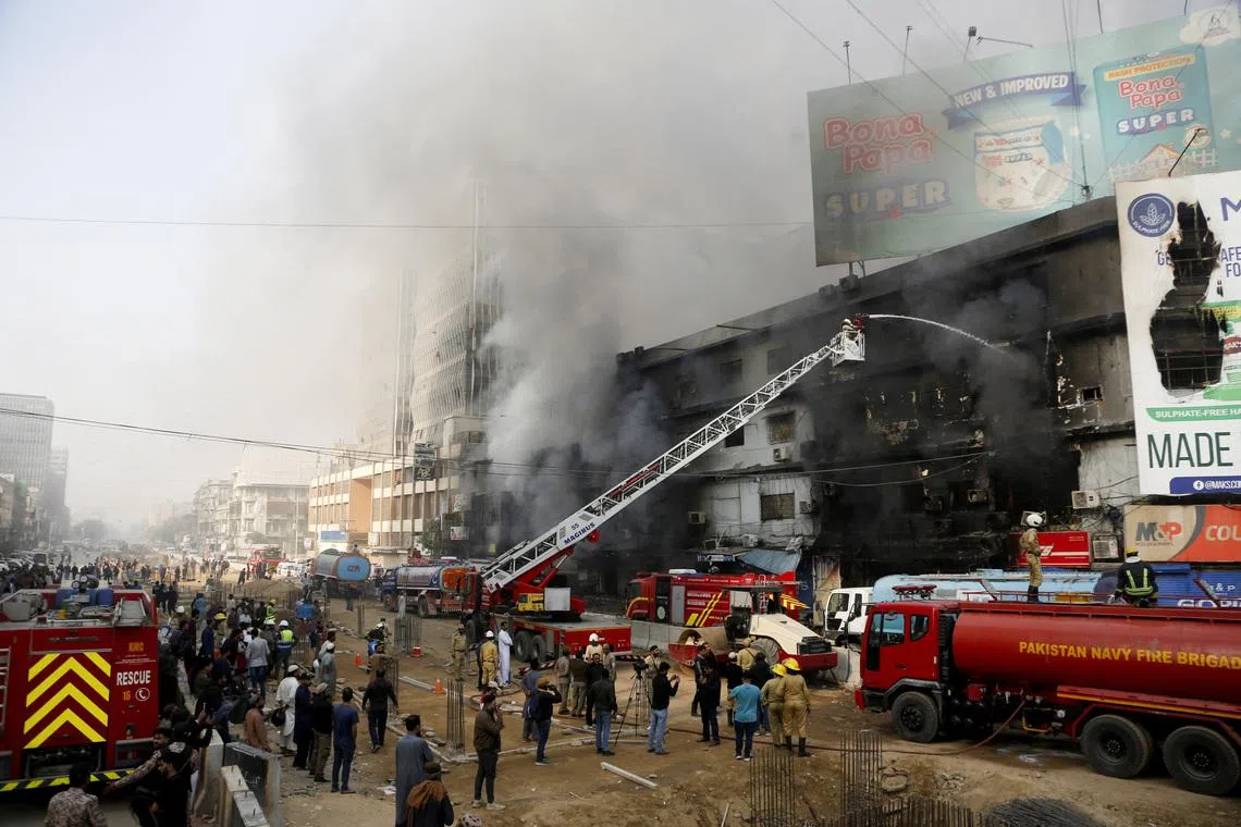 Smoke rises as firefighters spray water to extinguish a massive fire that broke out in the Gul Plaza Shopping Centre building, in Karachi, Pakistan, January 18, 2026. REUTERS/Stringer