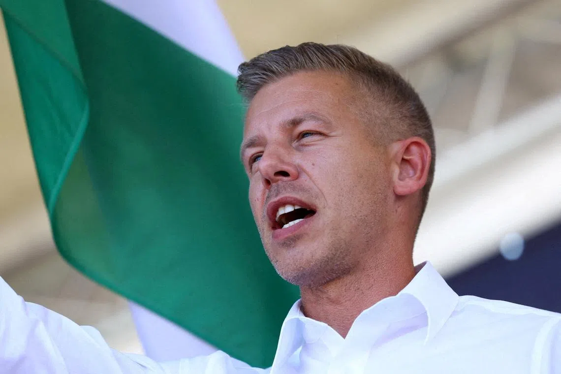 FILE PHOTO: Peter Magyar, leader of the opposition Tisza party, waves a Hungarian flag at a rally near the venue of ruling Fidesz party closed doors meeting where Prime Minister Viktor Orban discusses campaign issues with party officials in Kotcse, Hungary September 7, 2025. REUTERS/Bernadett Szabo//File Photo