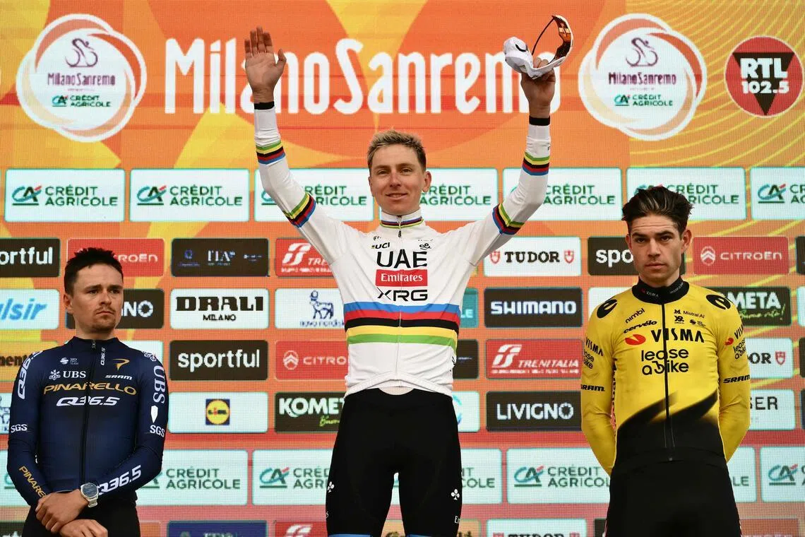 Slovenian rider Tadej Pogacar celebrating on the podium of the 117th Milan-San Remo one-day classic cycling race, with second-placed Briton Thomas Pidcock (left) and third-placed Belgian Wout van Aert on March 21, 2026.