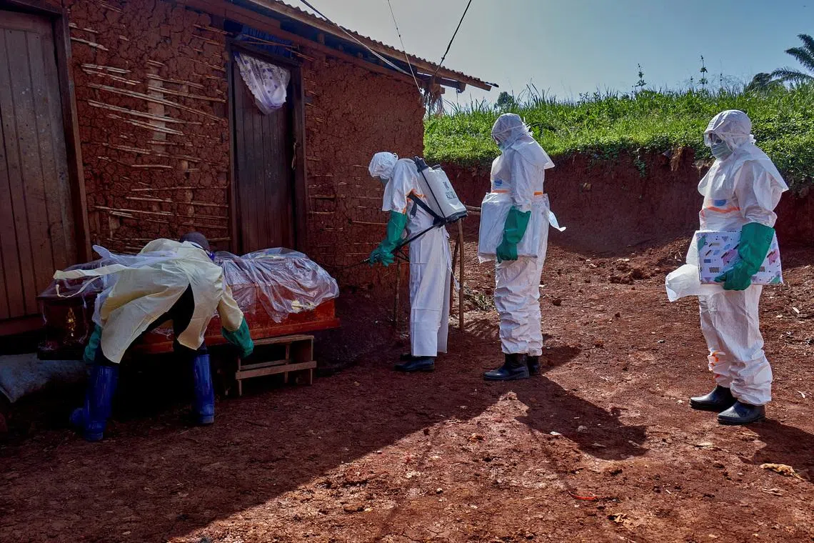 Red Cross workers wearing personal protective equipment as they disinfect the house of a man who died of Ebola, in Mongbwalu, Democratic Republic of the Congo, on May 24.