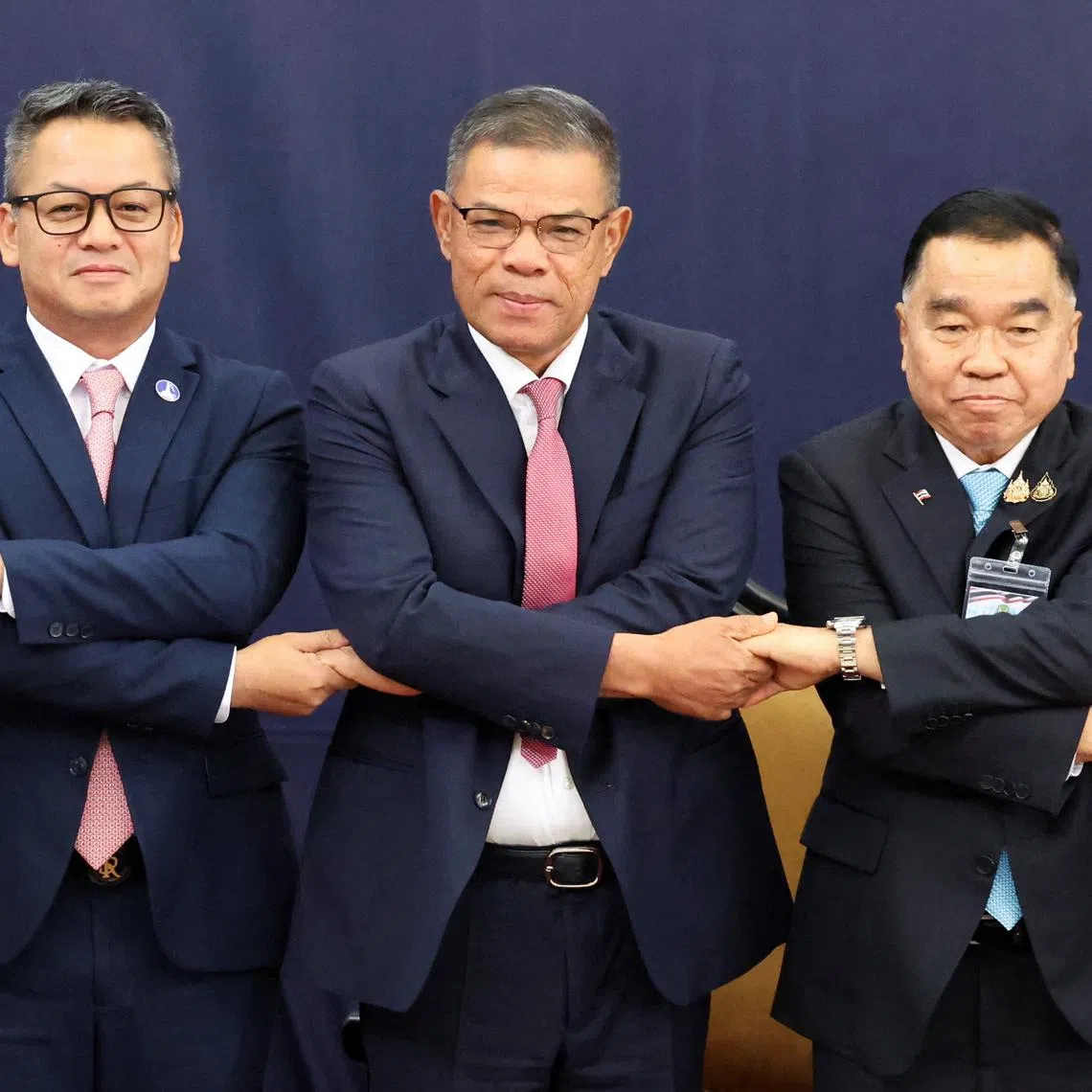 Thai Deputy Defence Minister Nattaphon Narkphanit, Malaysian Home Minister Saifuddin Nasution Ismail and Cambodian Defence Minister General Tea Seiha join hands for a group photo ahead of the Extraordinary General Border Committee (GBC) to discuss border dispute between Thailand and Cambodia in Kuala Lumpur, Malaysia August 7, 2025. REUTERS/Hasnoor Hussain/Pool