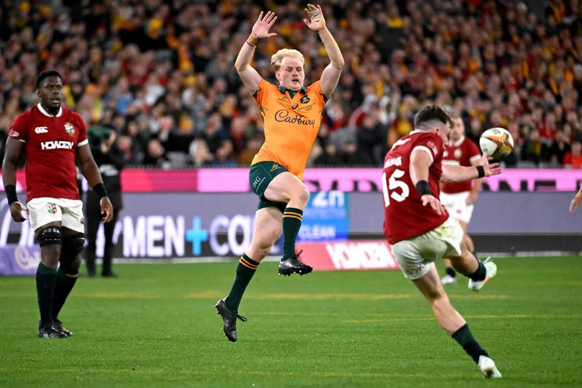 British and Irish Lions’ Hugo Keenan clears the ball as Australia’s Tom Lynagh attempts a charge down in the second rugby Test match at the Melbourne Cricket Ground on July 26, 2025.