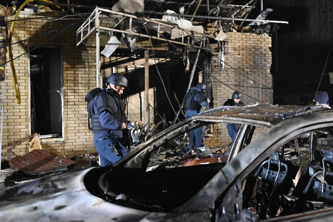 Rescuers work in a shop destroyed following a Russian missile attack on Oct 11 in Pesochin settlement, a suburb of Kharkiv, which killed three people and wounded 22.