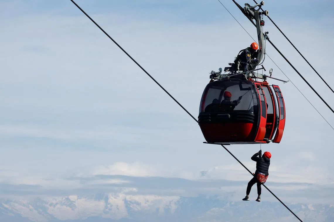 Members of the Armed Police Force take part in a drill on how to rescue people from a stuck cable car at Chandragiri Cable Car in Kathmandu, Nepal, on Feb 27.