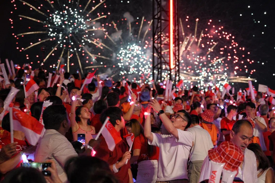 Spectators enjoy the fireworks at the end of the Padang during the National Day Parade at the Padang on Aug 9, 2025.