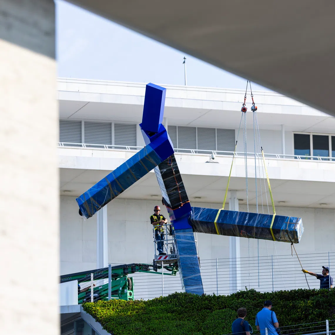 Workers remove a large sculpture called ‘Blue’ by artist Joel Shapiro from the grounds of the John F. Kennedy Center for the Performing Arts on Sept 2 in Washington DC, US.
