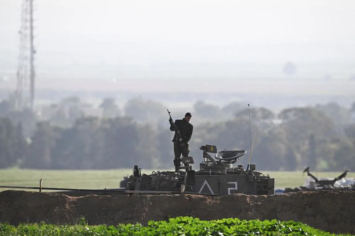 A soldier stands atop an artillery unit, amid the ongoing conflict between Israel and the Palestinian Islamist group Hamas, near the Israel-Gaza border, Israel, February 14, 2024. REUTERS/Dylan Martinez