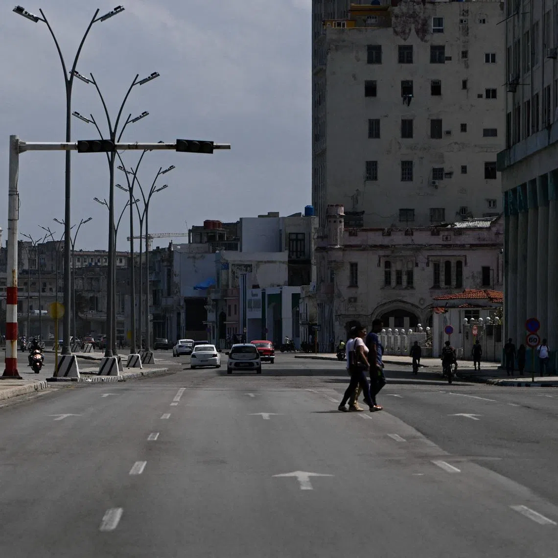 People cross an avenue as traffic lights are off during a mass blackout across most of the country, in Havana, Cuba March 4, 2026. REUTERS/Norlys Perez