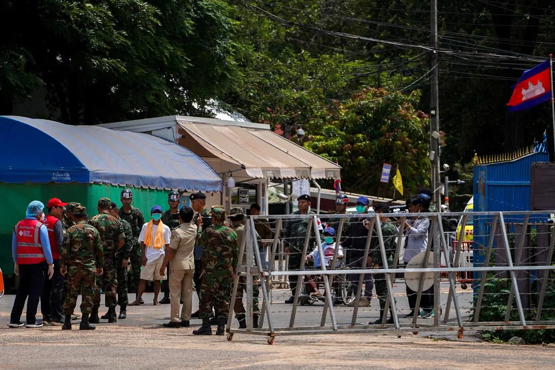 Two Cambodian soldiers (in white shirts), who were detained in Thailand, being released from captivity on Aug 1.