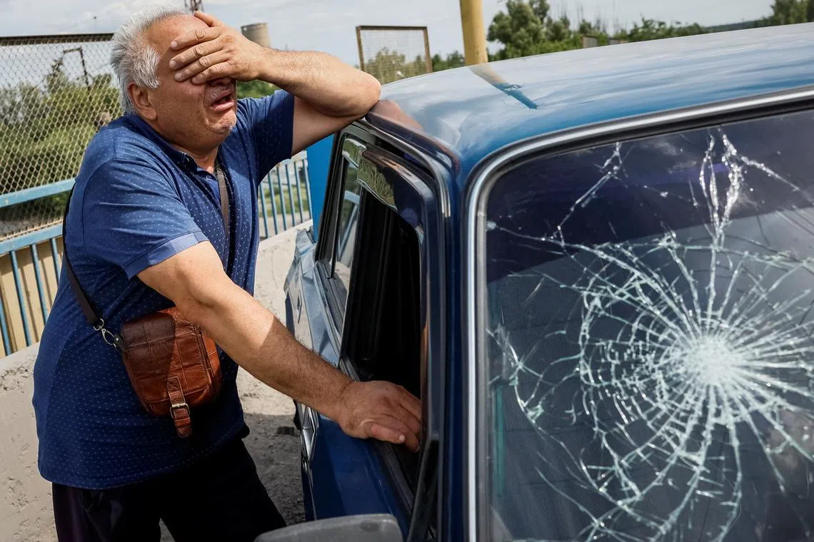 A person reacts next to a damaged car, where his son was killed, at a site of a Russian missile strike, amid Russia's attack on Ukraine, in Pokrovsk, Donetsk region Ukraine June 24, 2024. REUTERS/Alina Smutko