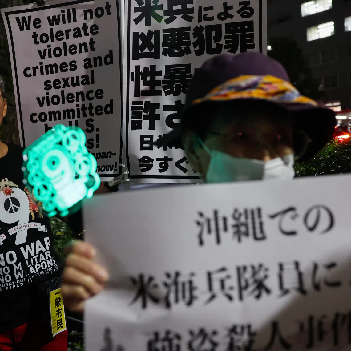 Demonstrators hold placards during a protest outside Foreign Ministry building following the killing of a Japanese woman in Okinawa, for which a US Marine is a suspect, in Tokyo, Japan, October 8, 2026. REUTERS/Kim Kyung-Hoon