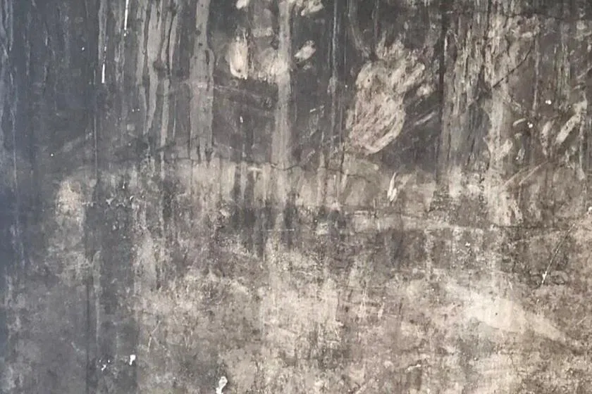 FILE PHOTO: Handprints on a blackened wall at the Grenfell Tower block of flats, the site of a June 2017 deadly fire, s family members of victims have said they will take legal action against the government unless it reverses a decision not to preserve a section of the tower's wall, bearing handprints they believe belong to victims or survivors, for a future memorial, in London, Britain, July 2025. Work to dismantle the tower started in September 2025. Karim Khalloufi/Handout via REUTERS/File Photo