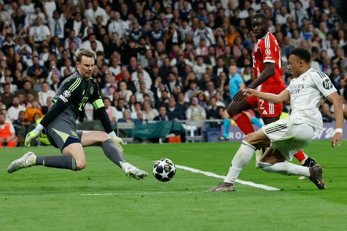 Real Madrid's French forward Kylian Mbappe being denied by German goalkeeper Manuel Neuer during Bayern Munich's 2-1 Champions League quarter-final, first-leg win at the Santiago Bernabeu Stadium in Madrid on April 7, 2026.