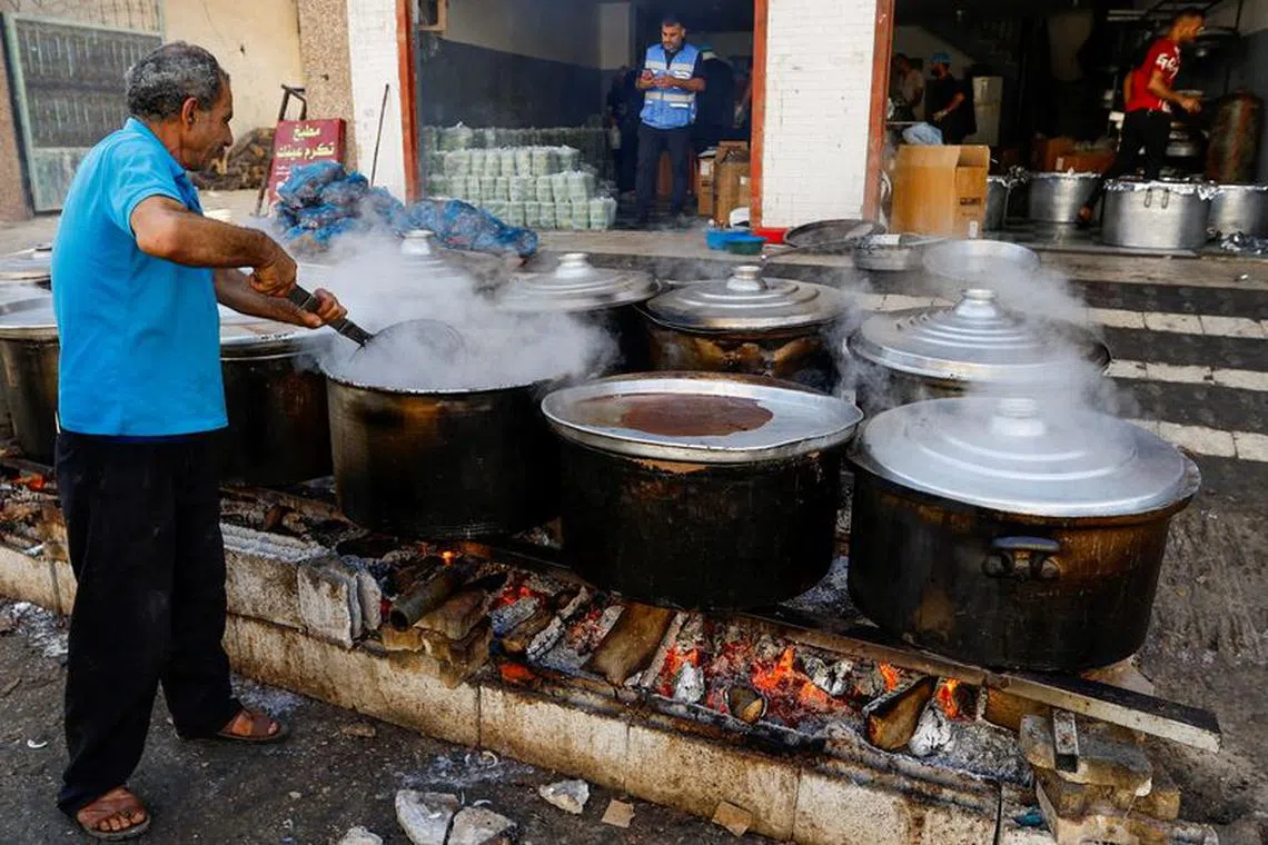 FILE PHOTO: Palestinians cook on firewood, amid fuel and cooking gas shortages, as the conflict between Israel and Hamas continues, in Khan Younis in the southern Gaza Strip, November 5, 2023. REUTERS/Ibraheem Abu Mustafa/File Photo