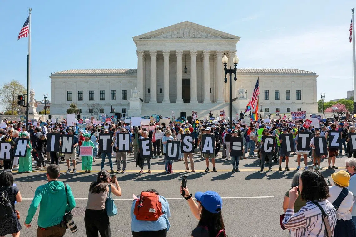 FILE PHOTO: Demonstrators hold letters making up the slogan \"Born in the USA = citizen!\" outside the U.S. Supreme Court building as the court hears oral arguments on the legality of the Trump administration's effort to limit birthright citizenship for the children of immigrants, in Washington, D.C., U.S., April 1, 2026. REUTERS/Kylie Cooper/File Photo