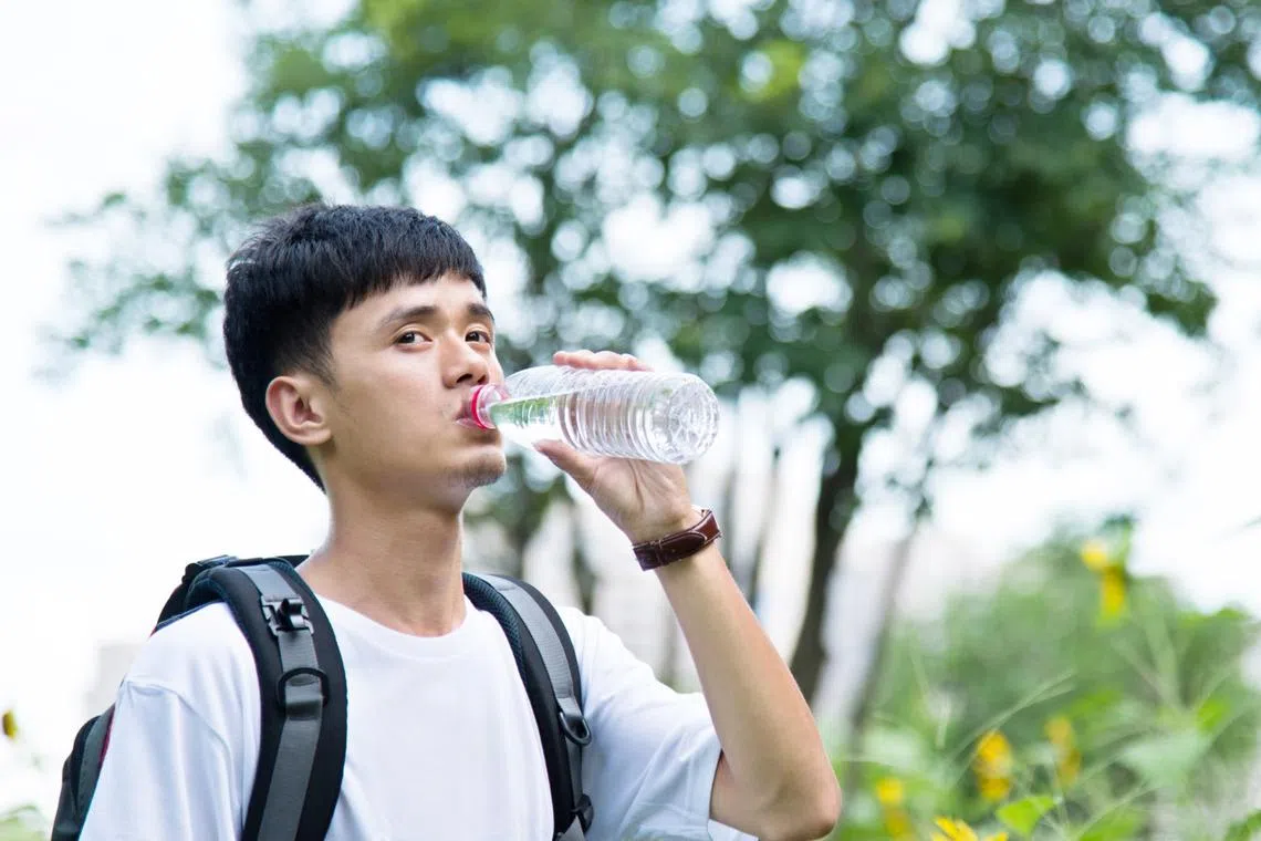 lady drinking more water as remedy for tension headaches often caused by dehydration
