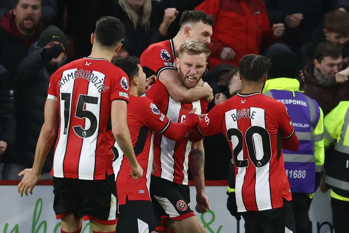 Sheffield United's Ollie McBurnie (centre) celebrates with teammates after scoring a penalty in the 103rd minute.