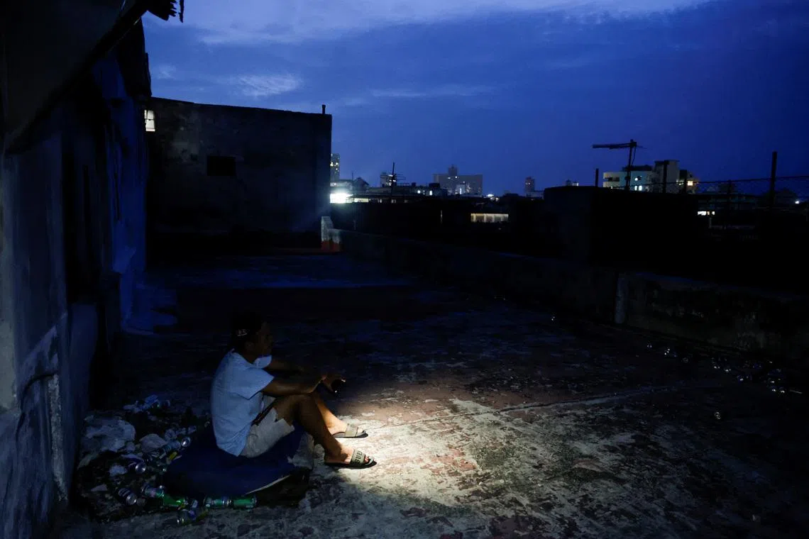 Frank Alfonso, 39, sits on a mattress on the roof of a building to keep cool as Cuba's national power grid collapsed, marking the second total blackout in a week amid a severe energy crisis that has turned power outages into a daily reality, in Havana, Cuba, July 11, 2026. REUTERS/Norlys Perez