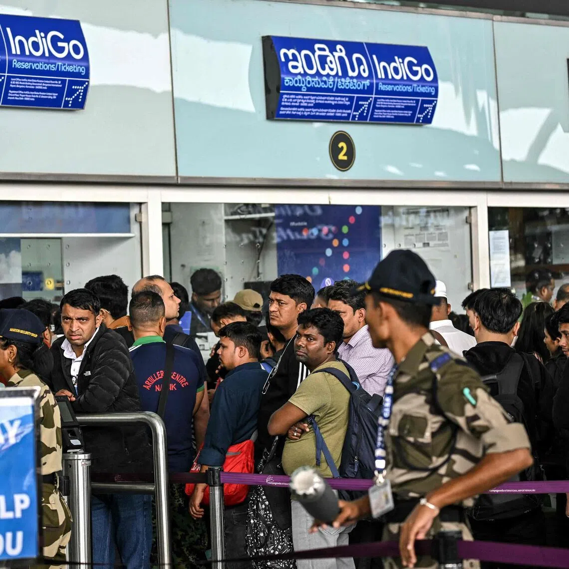 Passengers wait outside the IndiGo Airlines kiosk at the Kempegowda International Airport in Bengaluru on Dec 6, 2025.